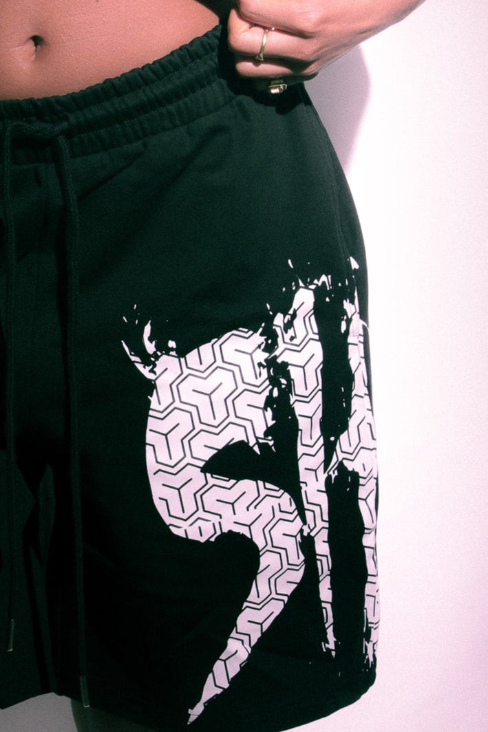 Person wearing black shorts with white graphics on a plain background