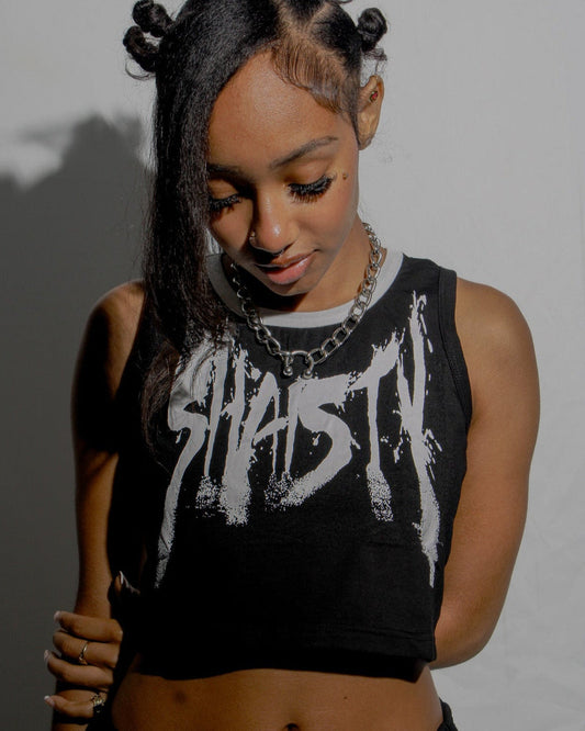 Person wearing a black tank top with white text against a plain background